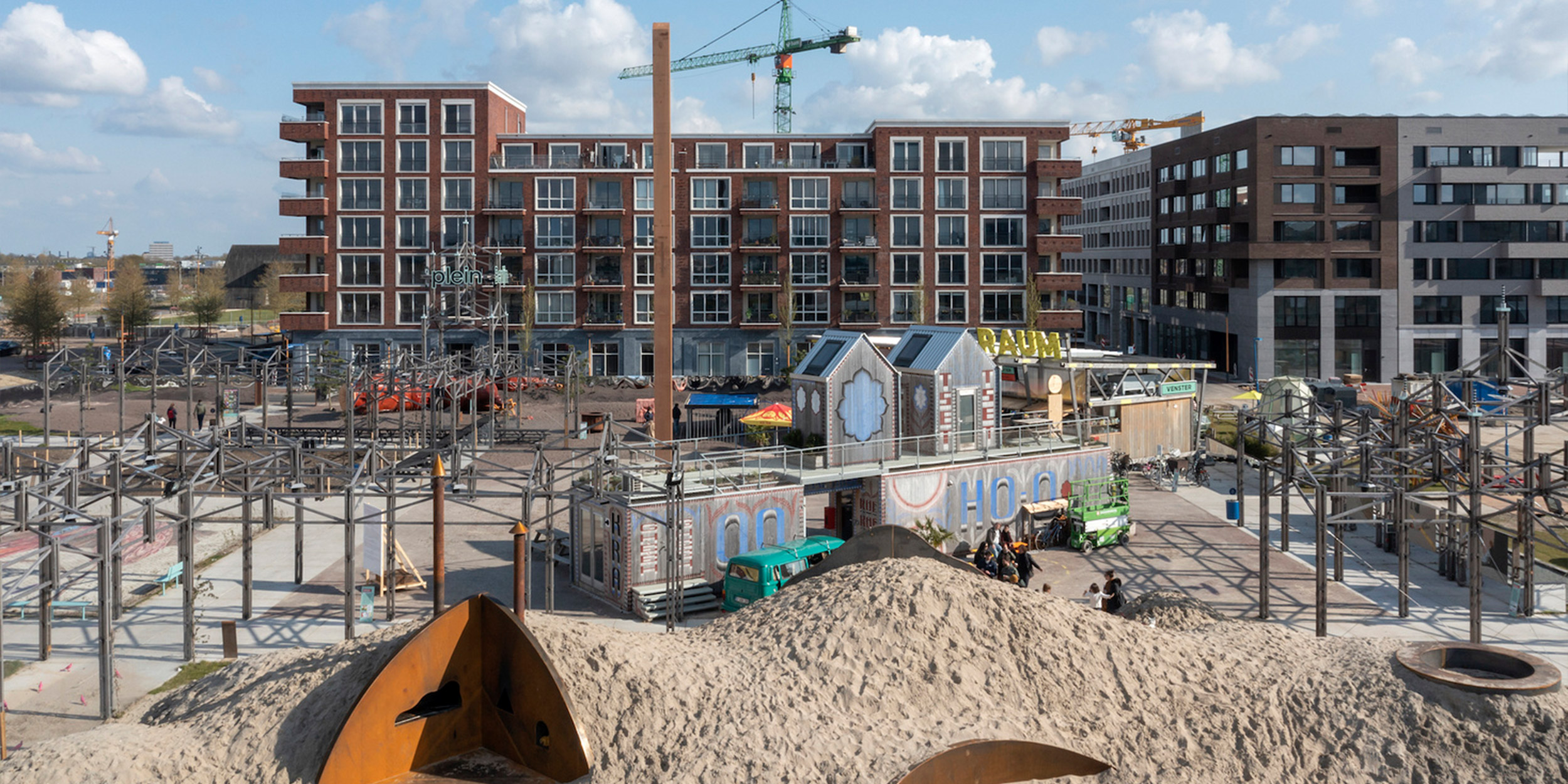 Een stukje van raum in Utrecht, met een grote zandheuvel, een aantal containerruimtes en verschillende kunstwerken op het plein. Afdeling-Buitengewone-Zaken---RAUM---2